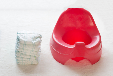Children's red pot and a stack of diapers, hygiene and diaperの写真素材