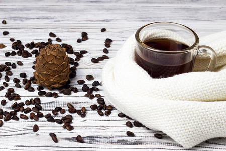 Cedar cone and pine nuts, a cup of tea on a white wooden background, close-upの写真素材