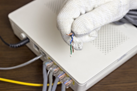 A man holds a network cable in his hand, a close-upの写真素材