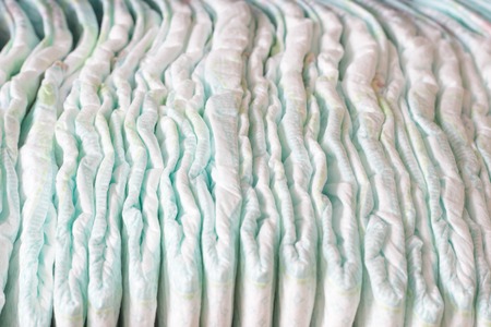 A large stack of baby diapers, close-ups, diaper packaging, whiteの写真素材