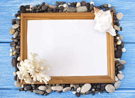 Frame of sea stones and seashells on a blue wooden background, summerの写真素材