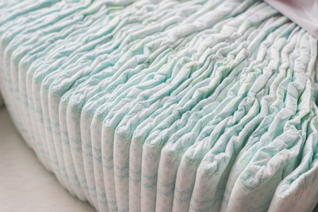 A large stack of baby diapers, close-ups, diaper packaging, whiteの写真素材