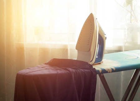 Iron on ironing board and shirt, close-up, exposure, houseworkの写真素材