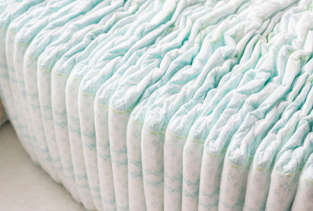 A large stack of baby diapers, close-ups, diaper packaging, whiteの写真素材