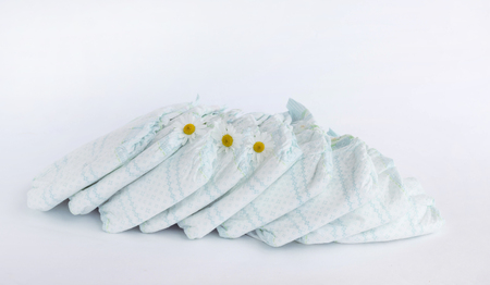 Baby diapers on a white background and chamomile flowers, camomile and diaperの写真素材