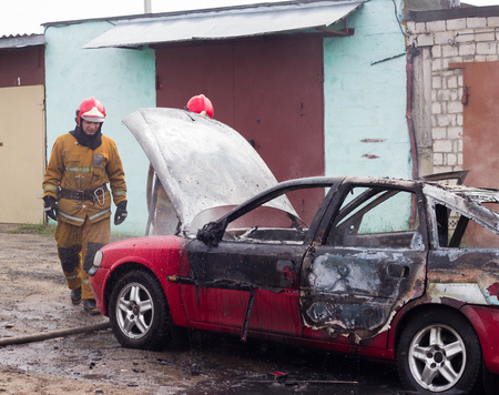 BOBRUISK, BELARUS - JULY 25, 2018: Two firemen extinguish a burning car, fire, firefighterのeditorial素材