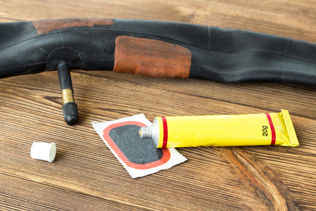 A set for sealing holes in chambers on a wooden background, a bicycle camera, bicycle, botchの写真素材