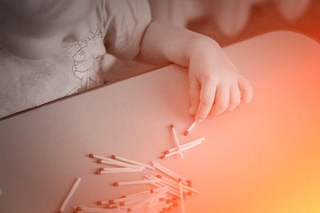 A small child plays with matches, a fire, a fire flares up, danger, child and matches, dangerous, ignitionの写真素材