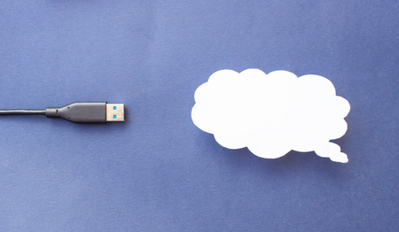 Cloud for data storage cut from paper on a blue background and cable usb, close-up, cloudの写真素材