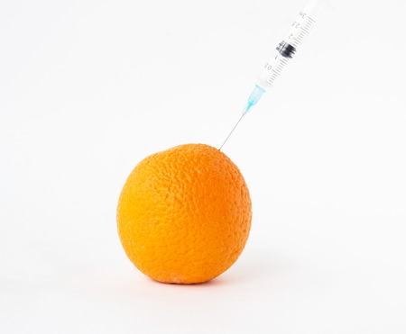 Orange on a white background in which enter gmo and nitrates, close-up, nitrates and orangeの写真素材