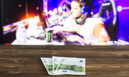 Euro money on the background of a TV on which e-sports is shown, sports betting, cybersport euroの写真素材