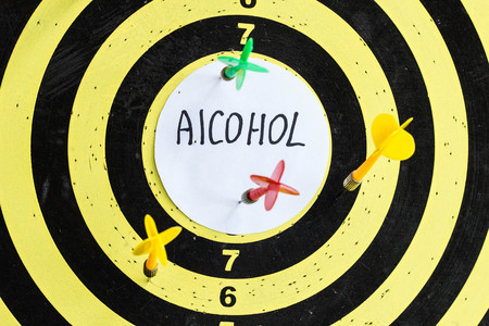 Target with darts in the center of which the inscription alcohol, close upの写真素材