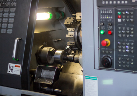CNC lathe pulls out part of metal workpiece pulley, modern lathe for metal processing, close-up,...