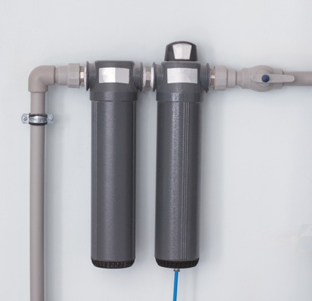 Two modern water filters for cleaning large amounts of water, water filters are located on the wall, close-up, water purificationの写真素材