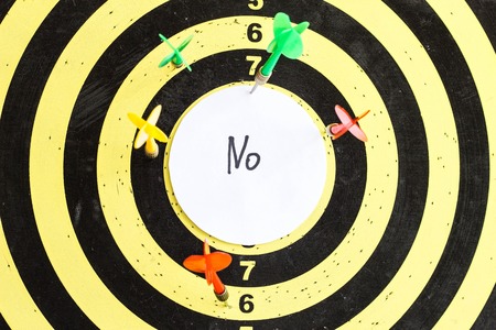 Target with darts in the center of which the inscription no, close-upの写真素材