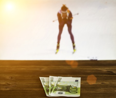Euro money on the background of the TV on which the biathlon show, sports betting, euroの写真素材