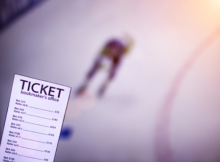 Bookmaker ticket on the background of a TV on which show skating sports, sports betting, skatingの写真素材