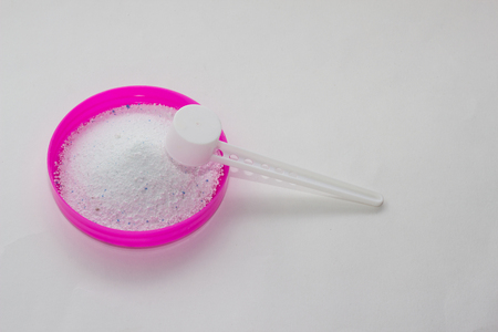 Stain remover and bleach on a red cover with a measuring spoon on a white background, close-up, stackの写真素材