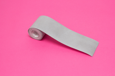 Silver tape to reflect light on a pink background, close-up, visibility on the road, safety, visibilityの写真素材