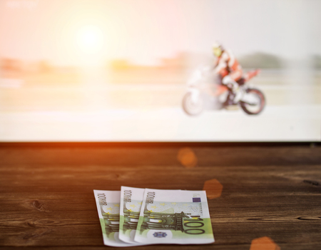 Euro money on the background of the TV on which show motorcycle racing, sports betting, motorcycle racesの写真素材