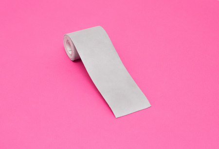 Silver tape to reflect light on a pink background, close-up, visibility on the road, safetyの写真素材