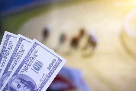 Money dollars on the background of a TV on which show a dog race, sports betting, dog Racingの写真素材