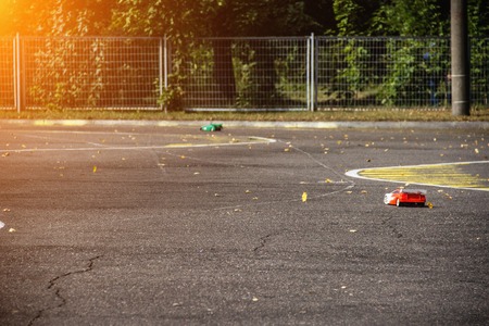 Competitions on auto sport on the radio, two cars on the radio go on an asphalt road, the sun,...