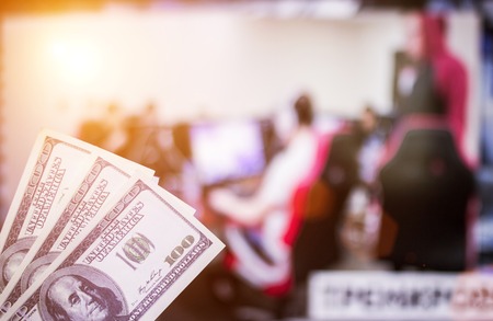 Money dollars against the background of a TV on which e-sports are shown, sports betting, dollarsの写真素材