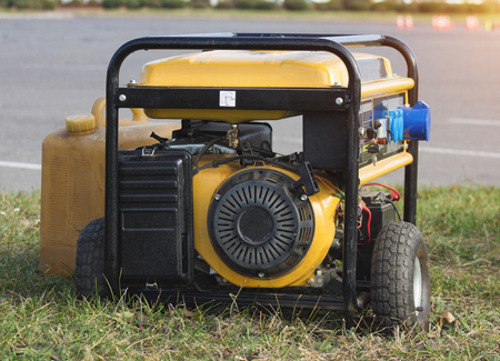 yellow petrol portable generator on wheels, close-up, alternator