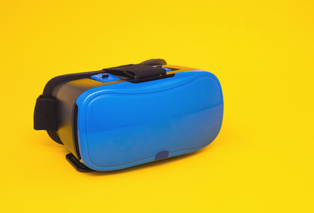 Modern blue glasses of virtual reality for smartphone and phone on yellow background, close-up, multimedia, simulatorの写真素材