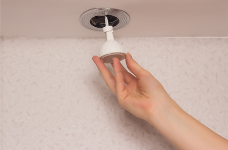 Recessed downlight with LED energy saving bulb, close-up, installation, hand, copy space, armの写真素材