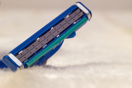 Men's beard shaver on white fleecy material, macro, male shave, copy space, pileの写真素材