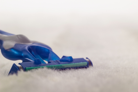 Men's beard shaver on white fleecy material, macro, male shave, copy space, groomingの写真素材