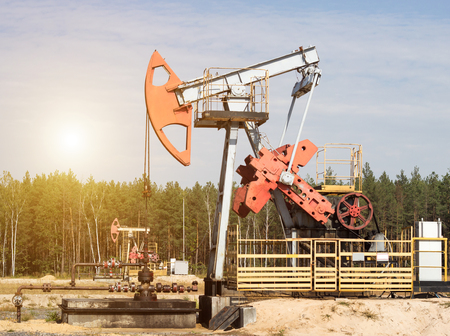Oil well for the production of oil and gasoline and gas on the background of the forest, the production of gasoline, pumpjack, extraction of petroleumの写真素材