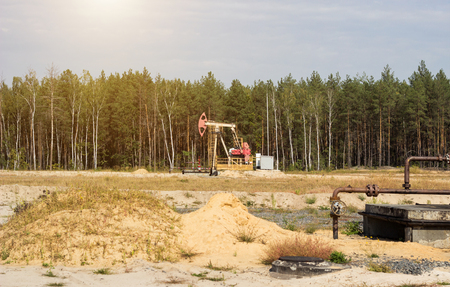 Oil well for the extraction of oil and gasoline and gas on the background of the forest, the production of fuel-combustible and petroleum substances, the extraction of petroleum products, equipmentの写真素材
