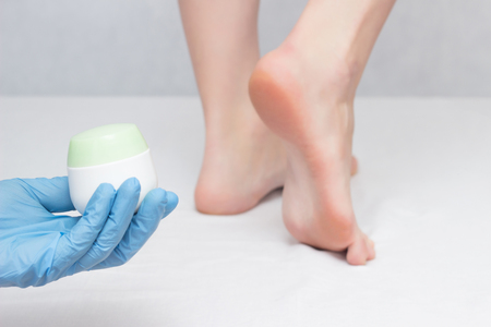 Doctor holds healing heel cream, against fungus and dry skin, close-up, white background, dermatitisの写真素材
