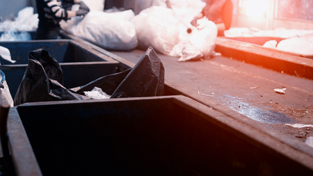 Workers select and sort garbage that travels on a conveyor belt in a waste recycling plant, polyethyleneの写真素材