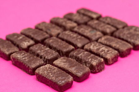 a lot of chocolates on a pink background, the background of chocolatesの写真素材