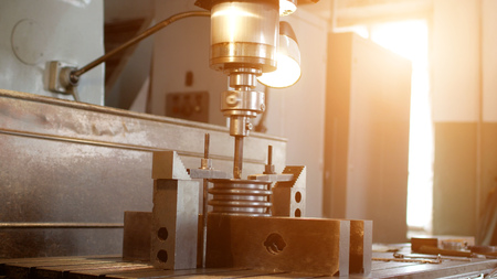 Drilling a hole with a drilling machine in a metal workpiece pulley, close-up, industry, reamingの写真素材
