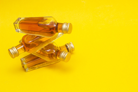 Small bottles with alcohol on a yellow background, close-up, copy space, duty-freeの写真素材