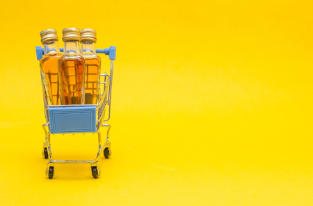 Small shopping trolley in which small bottles of alcohol, import and export of alcohol, copy space, shoppingの写真素材