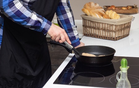 A man fries fatty cutlets in a pan, a lot of fat, junk food, close-upの写真素材
