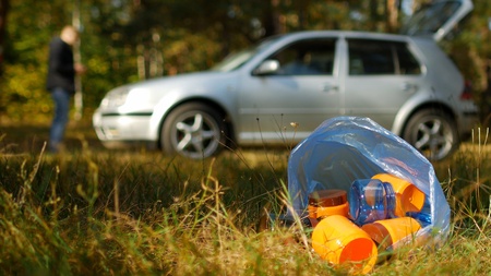 A car in the forest and a package of garbage in the foreground, outdoor recreation and forest pollution, trashの写真素材