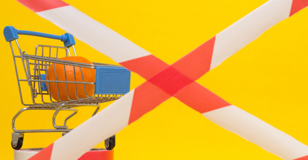 Shopping cart in which lies the mandarin, banned tape, the concept of sanctions on the import of goods and products, backgroundの写真素材