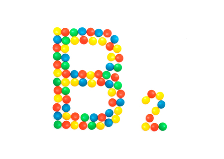 Multi-colored vitamins pills that are lined with the letter Vitamin B2, close-up, medicamentの写真素材