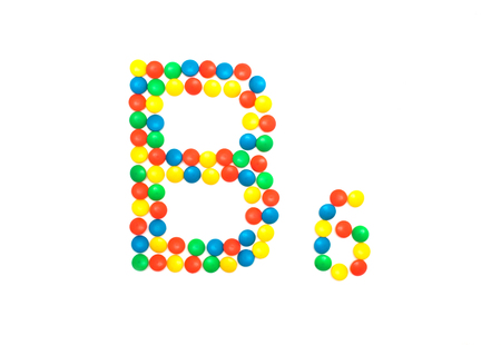 Multi-colored vitamins pills that are lined with the letter Vitamin B6, close-up, medicamentの写真素材