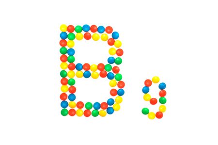 Multi-colored vitamins pills that are lined with the letter Vitamin B9, close-up, medicamentの写真素材