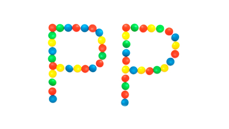 Multi-colored vitamins pills that are lined with the letter Vitamin PP, close-up, medicamentの写真素材