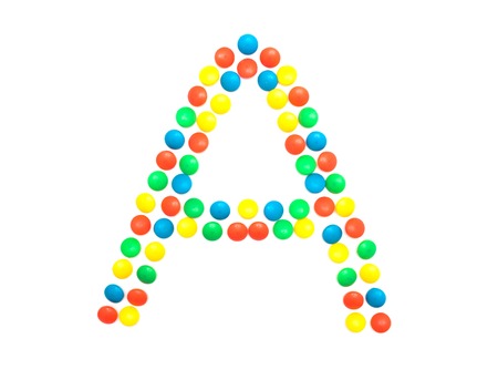 Multi-colored vitamins pills that are lined with the letter Vitamin A, close-up, medicamentの写真素材