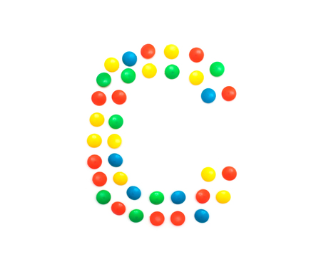 Multi-colored vitamins pills that are lined with the letter Vitamin C, close-up, medicamentの写真素材